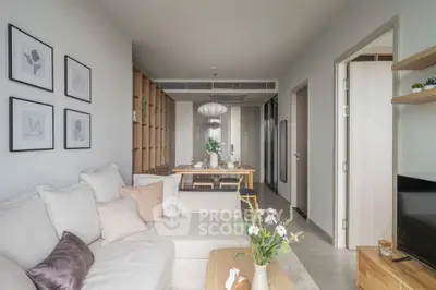Modern living room with cozy sofa and elegant dining area in open layout apartment.