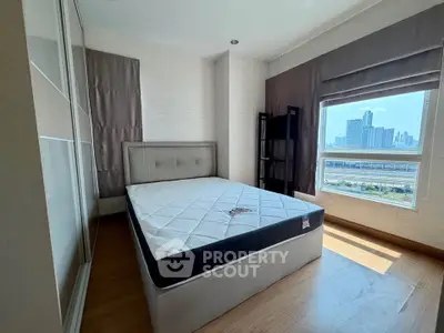 Modern bedroom with city view, featuring a stylish bed and large window for natural light.