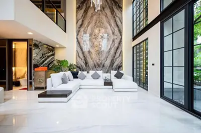 Luxurious modern living room with high ceilings and elegant marble accent wall