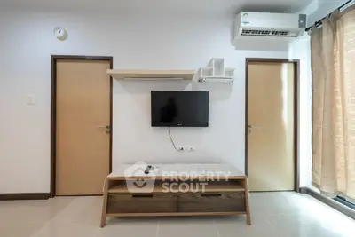 Modern living room with wall-mounted TV and minimalist furniture design.