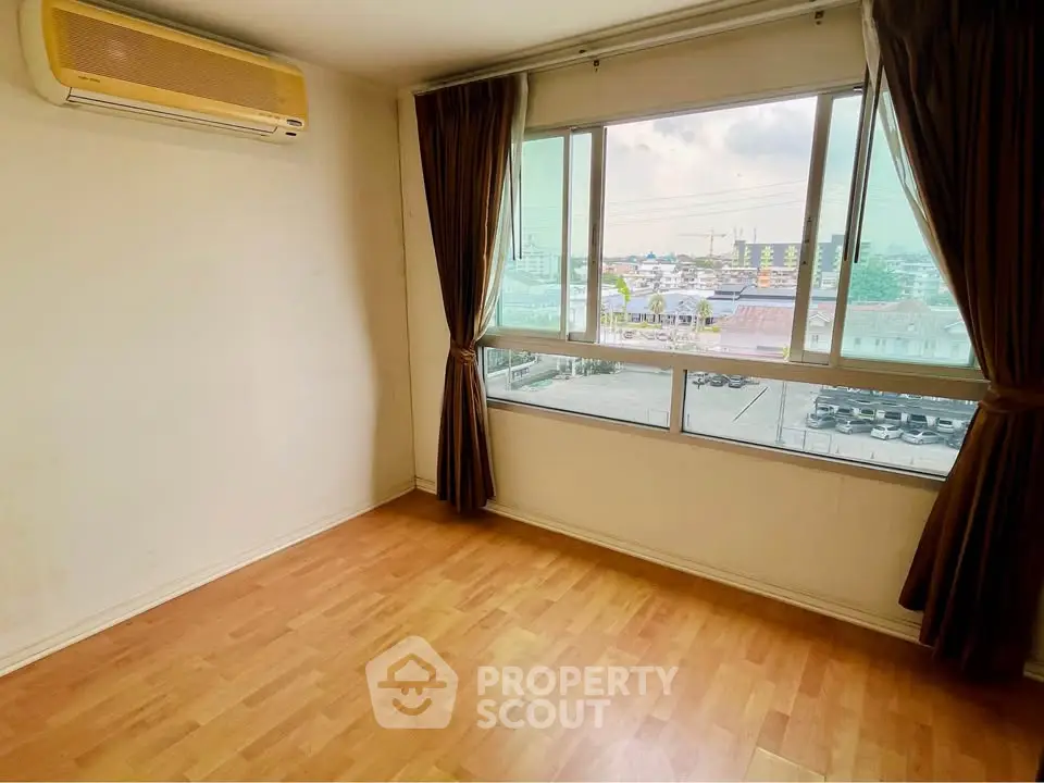 Spacious room with large window and air conditioning, offering a bright and airy atmosphere.