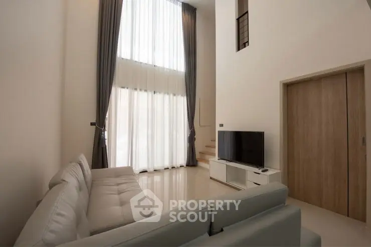 Spacious modern living room with high ceilings and large windows