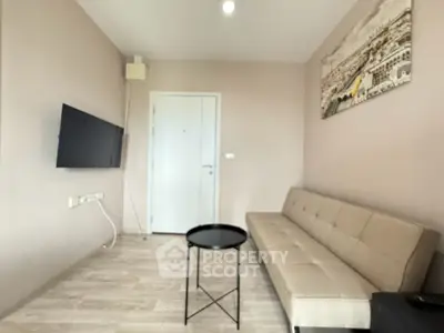 Modern living room with sleek sofa and wall-mounted TV in a cozy apartment.