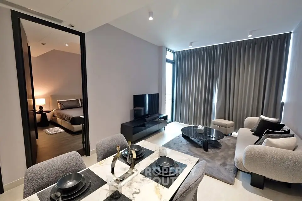 Modern open-plan living room with dining area and cozy bedroom view