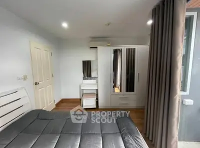 Cozy bedroom with modern furniture and ample natural light, perfect for relaxation and comfort.