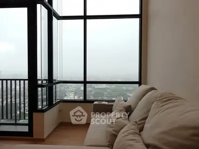 Spacious living room with large windows offering panoramic city views.