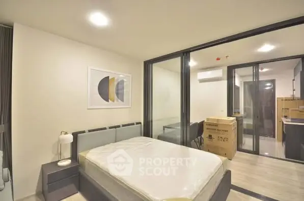 Modern bedroom with sleek design and large glass partitions in a contemporary apartment.