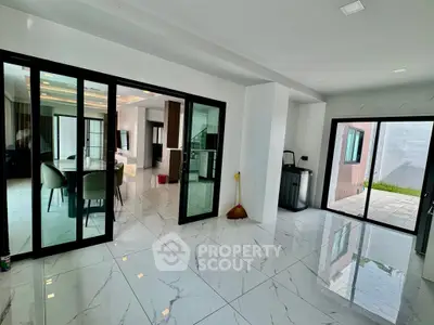 Spacious modern living area with sleek marble flooring and glass doors