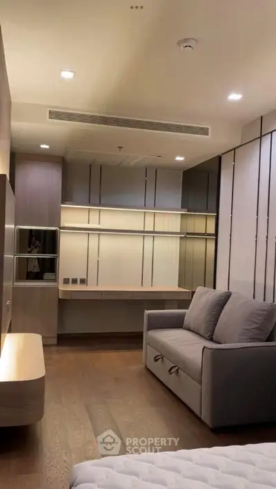 Modern bedroom with sleek design, featuring a cozy sofa and stylish built-in shelves.