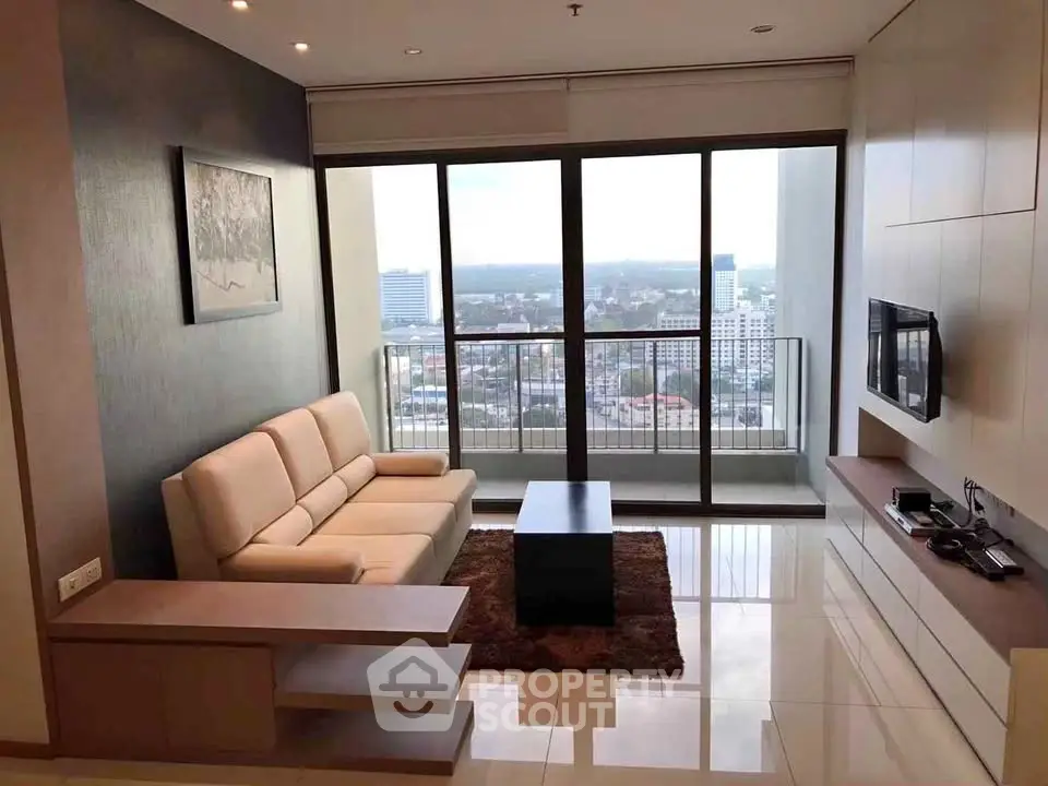 Modern living room with stunning city view and sleek furnishings in high-rise apartment.