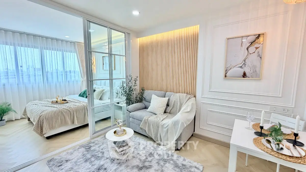 Modern open-plan living room with cozy decor and elegant bedroom view