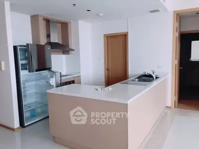 Modern kitchen with open layout and stainless steel appliances in a bright apartment.
