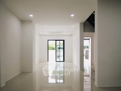 Spacious modern living room with glossy tiled floors and large windows for natural light.