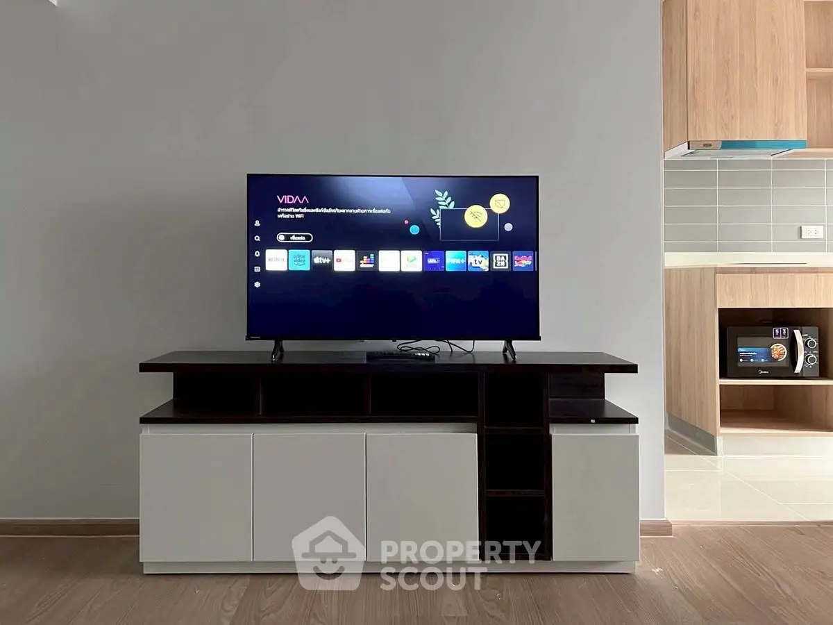 Modern living room with sleek TV stand and open kitchen layout, perfect for contemporary living.