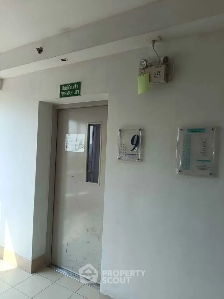 Fireman lift entrance on a residential building floor with signage and floor number.