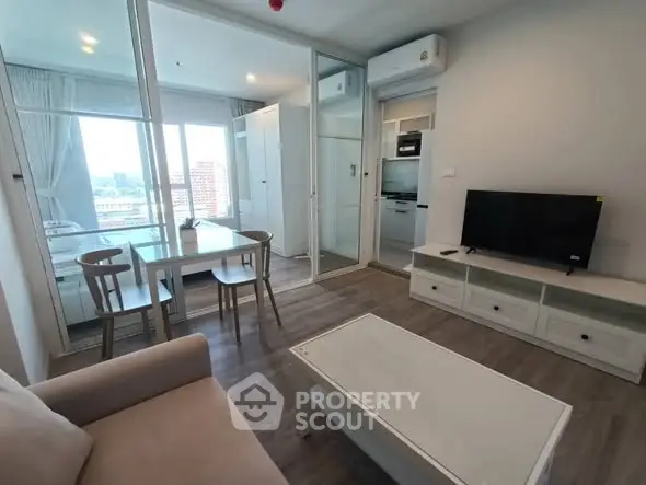 Modern living room with open layout and city view, featuring sleek furniture and natural light.