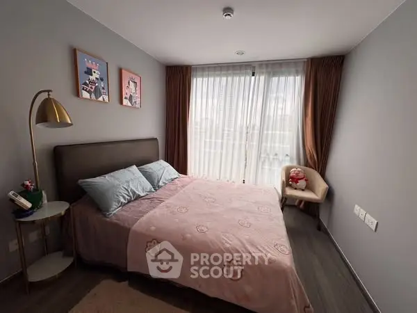 Cozy bedroom with stylish decor and large window for natural light
