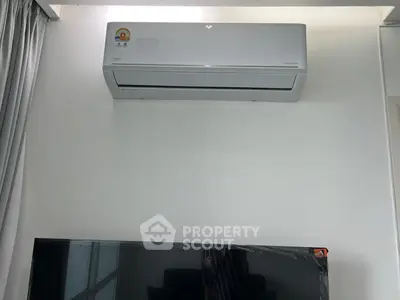 Modern air conditioning unit installed above a sleek television in a contemporary living space.