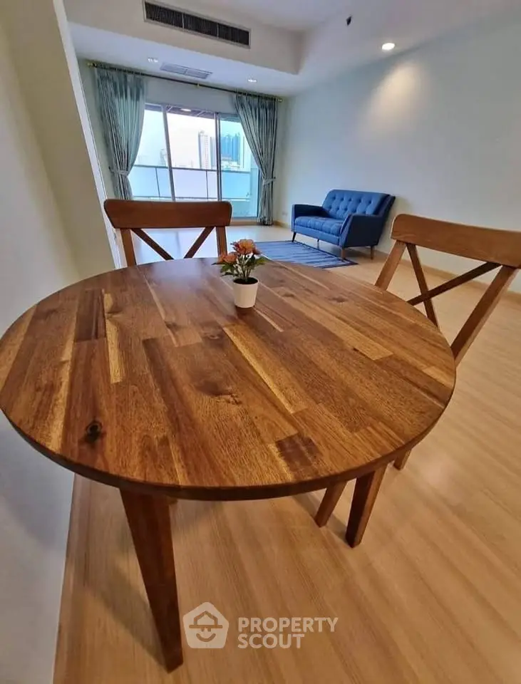 Spacious living room with wooden dining table and city view balcony