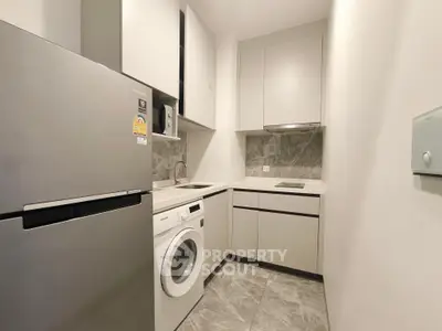 Modern compact kitchen with sleek appliances and minimalist design