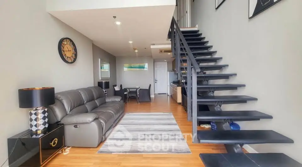 Modern loft-style living room with sleek staircase and stylish decor