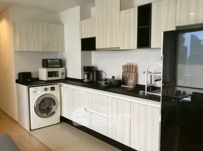 Modern kitchen with washing machine and sleek appliances in stylish apartment.