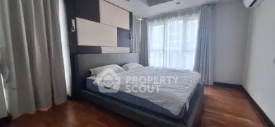 Spacious bedroom with modern design and large windows for natural light.