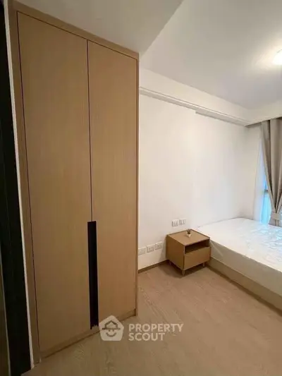 Modern bedroom with minimalist design featuring a sleek wardrobe and cozy bed.
