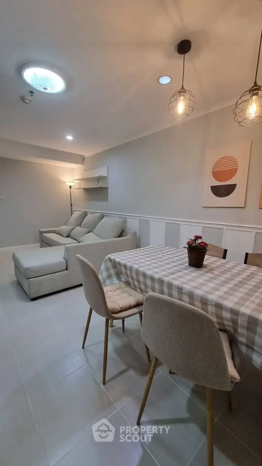 Charming living room with cozy sofa and stylish dining area, perfect for modern living.