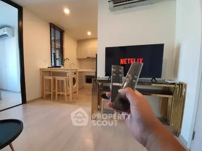 Modern living room with open kitchen and TV setup, perfect for cozy entertainment nights.