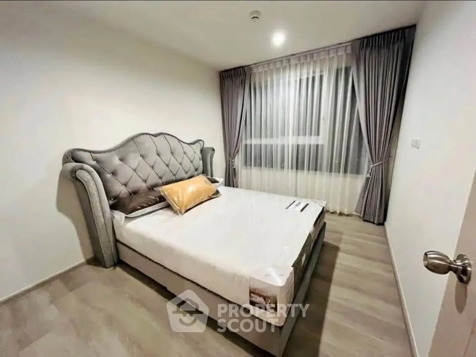 Modern bedroom with elegant bed and large window with curtains