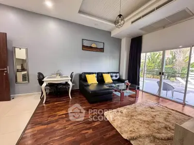 Spacious living room with modern decor and large windows overlooking lush greenery.