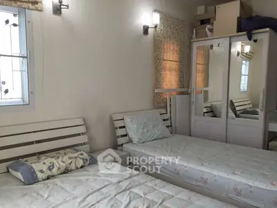 Cozy bedroom with twin beds and mirrored wardrobe, perfect for a comfortable stay.