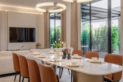 Luxurious dining area with elegant table setting and modern lighting in a spacious living room.