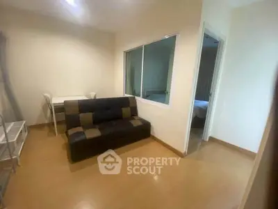 Cozy living room with modern sofa and study area in a well-lit apartment