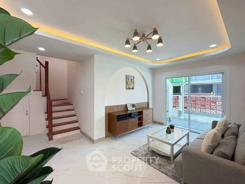 Modern living room with stylish lighting and balcony access in a contemporary home.