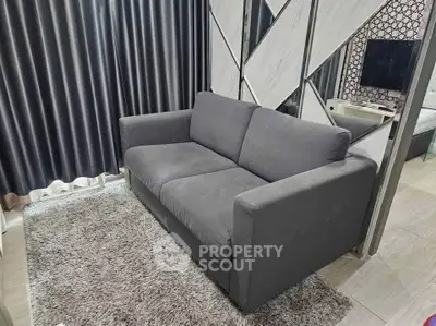 Modern living room with stylish gray sofa and plush rug, perfect for cozy relaxation.