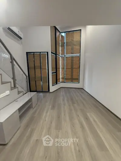 Modern living room with large windows and wooden flooring
