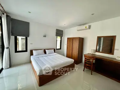 Spacious bedroom with modern furnishings and natural light, perfect for comfort and relaxation.