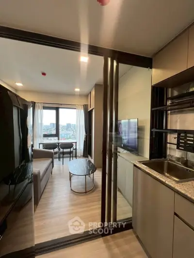 Modern apartment with open layout, featuring a cozy living room and sleek kitchen, offering a stunning city view.