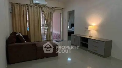 Cozy living room with sectional sofa and ambient lighting, leading to a balcony with curtains.