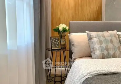 Cozy bedroom with elegant decor and soft lighting, featuring a stylish side table and plush bedding.