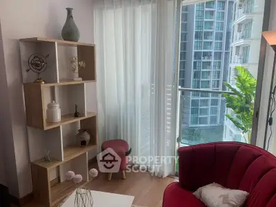 Chic modern living room with elegant decor and city view, featuring a stylish red chair and wooden shelving.