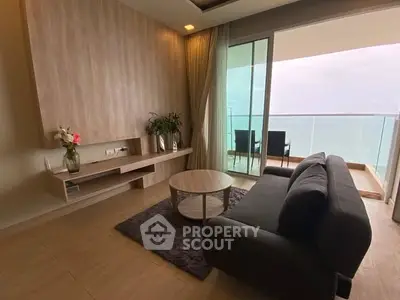 Modern living room with ocean view and spacious balcony, featuring sleek furniture and elegant decor.