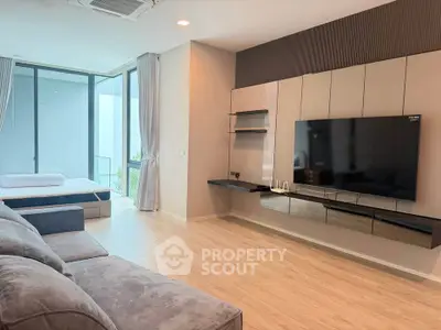 Spacious modern living room with large TV and cozy seating area