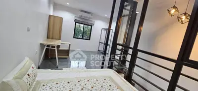 Modern bedroom with stylish decor and ample natural light, featuring a cozy bed and sleek furnishings.