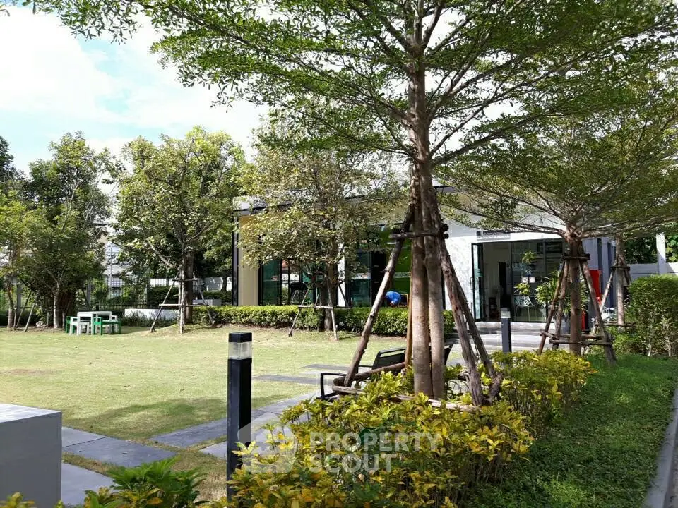 Lush garden area with modern building backdrop, perfect for relaxation and outdoor activities.