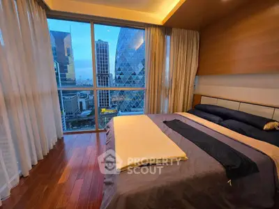 Luxurious bedroom with stunning city view and modern decor in high-rise apartment.