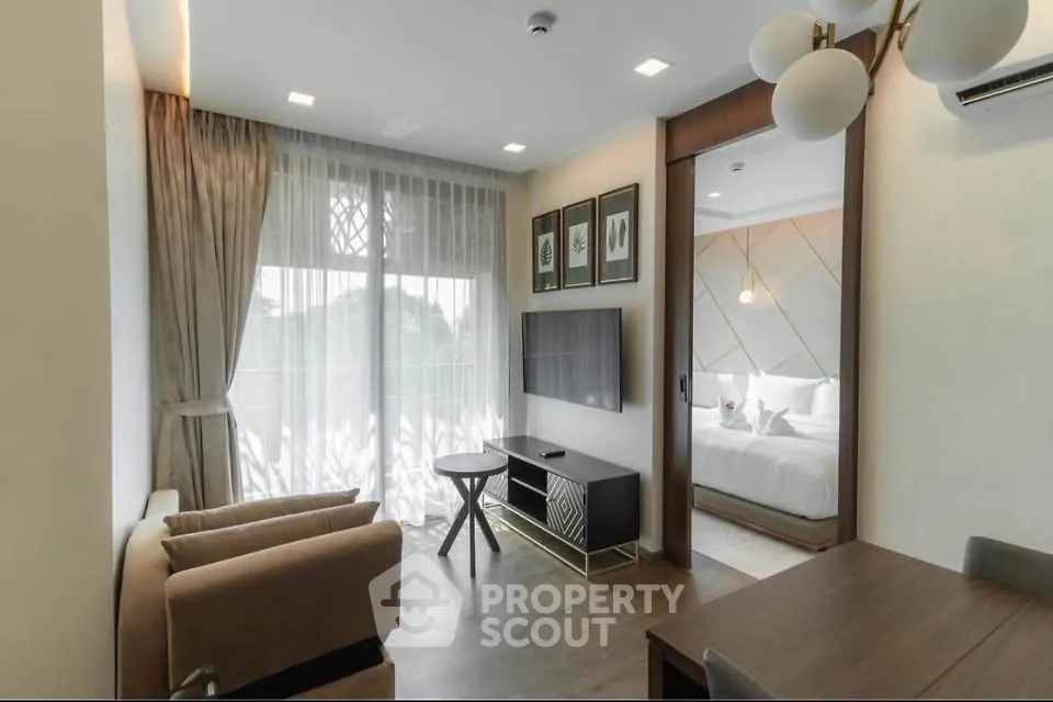 Modern living room with elegant decor and a view into a stylish bedroom