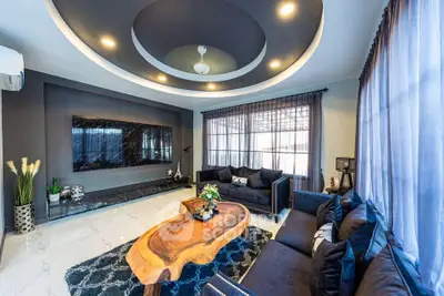 Luxurious living room with modern decor, large TV, and unique wooden coffee table.